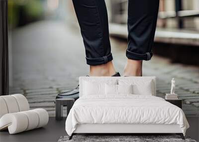 Close up of female legs in jeans wearing stylish black loafers shoes and socks showcasing trendy street style fashion with a copy space image Wall mural