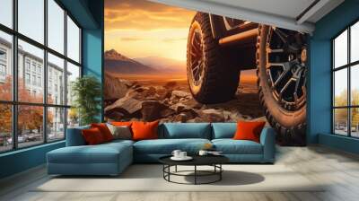 Close up photo of a large offroad wheel with a 4x4 car set against a sunset and mountains representing the travel concept Copy space image Place for adding text or design Wall mural