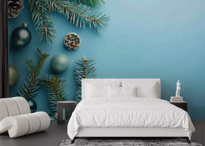 Coniferous branches and Christmas ornaments set against a blue background for New Year s copy space Wall mural