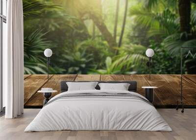 Empty wooden tabletop with a blurred background of a green tropical jungle in summer The table provides copyspace for displaying advertising products alongside a stunning forest banner background Wall mural