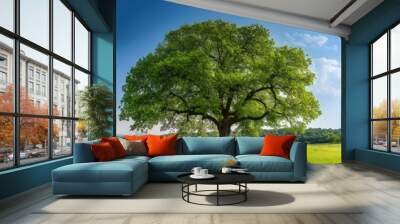 Lush spring meadow featuring a large tree surrounded by vibrant greenery, offering ample copy space for images. Wall mural