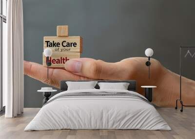 Medical professional s hand rests near wooden blocks displaying Take Care of your Health on a serene grey background for a symbolic health concept ample copy space image is available Wall mural