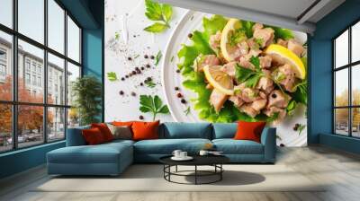 Pickled cod liver with lemon, fresh green lettuce on the white plate isolated pastel background. Copy space image. Place for adding text and design Wall mural