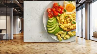 Plate featuring delicious scrambled eggs avocado and toast on a light background. Copy space image. Place for adding text and design Wall mural