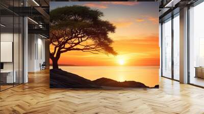 Silhouette of a large tree against a beautiful beach sunset scenery with copy space image Wall mural