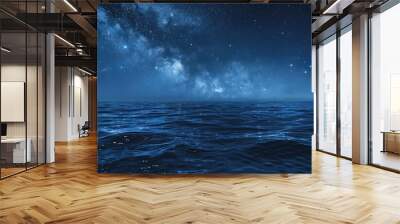 Starry night sky in blue hues above a serene ocean seascape with ample copy space image Wall mural