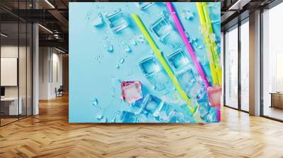 Top view of a vibrant summer themed arrangement featuring colorful cocktail straws and ice cubes on a light blue backdrop with copy space image Wall mural