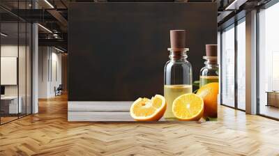 Two bottles of orange essential oil with fresh oranges on a table Wall mural