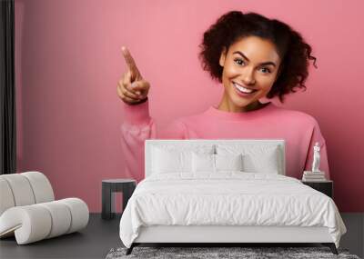 Cheerful young lady with two plaits raises finger Wall mural