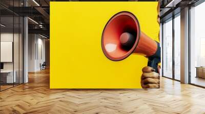 Dog holding a megaphone in its paws and barking into it, set against a solid background, humorously suggesting an announcement of discounts and promotions at a pet store. Wall mural