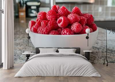 Freshly picked raspberries in a white bowl on a kitchen countertop ready for use in summer recipes. Close-up Wall mural