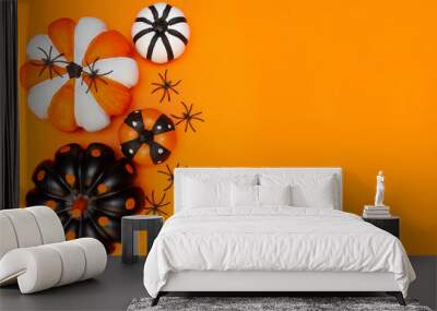 Halloween concept. Black spiders, four pumpkins in different colors and sizes. Place for text. Copy space. Flay lay. Top view. Layout for design. Orange background. Halloween card. Invitation. Wall mural