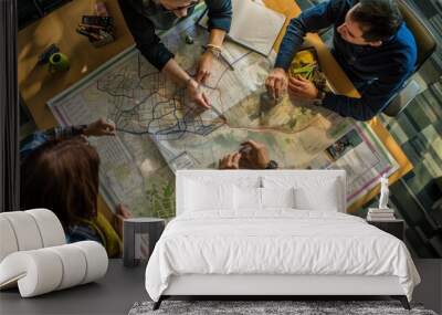 A group of people gathered around a table, examining a map for urban planning purposes Wall mural