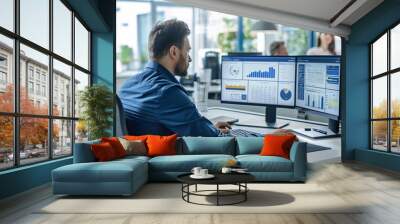 A man is seated at a modern office desk in front of a computer, navigating an online government portal Wall mural