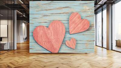 Three pink wooden hearts placed nicely on a blue vintage wood ba Wall mural