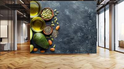 Healthy fats selection with avocado, nuts, seeds, olive oil on wooden background, space for text. Wall mural