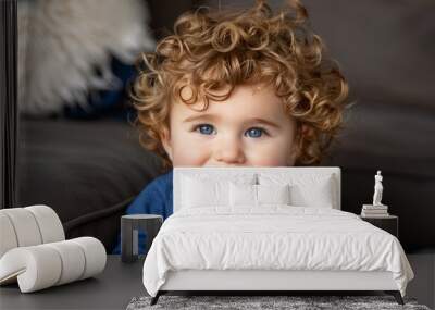 Joyful child with curly hair smiling and looking at the camera for a charming portrait Wall mural