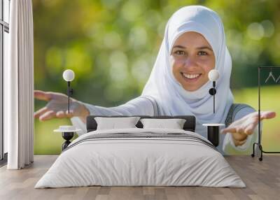 Radiant asian muslim woman smiling, offering eid mubarak greeting on blurred background Wall mural