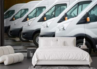 Row of new white vans in parking bay ready for work with blurred warehouse background and copy space Wall mural