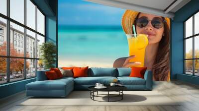 Sleek woman enjoying long island iced tea on a sunny beach with space for text placement Wall mural