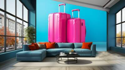 Vibrant blue background with two bright pink suitcases, travel luggage set for vacation Wall mural