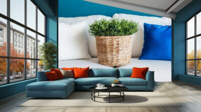 White Sofa, Blue Wall, and Colorful Pillows A Home Decor Scene with a Touch of Greenery. Wall mural