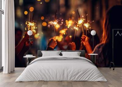 Winter holiday celebration group of happy people enjoying fireworks with glowing sparkles in hands Wall mural