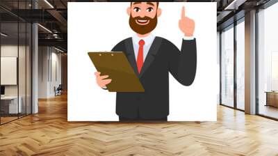 Young business man wearing a suit holding clipboard and pointing index finger up. Person keeping the file pad in hand. Male character design illustration. Modern lifestyle concept in vector cartoon. Wall mural