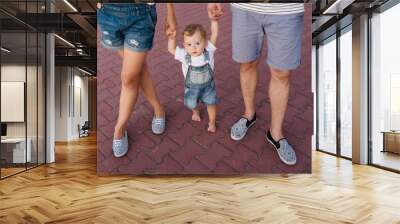 Little boy learns to walk and mother and father helps. Parenting support Wall mural