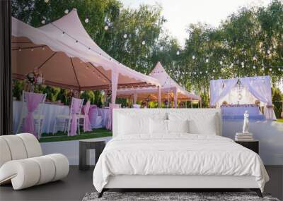 Wedding banquet outdoor in marquees on lawn decorated pink silk, lace and flowers Wall mural