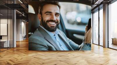 Businessman. Smiling executive man using a mobile phone sitting back seat of the car.  Wall mural