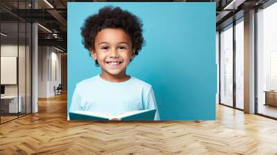 Reading book. little girl smiling with book on a blue background, school, back to school, education Wall mural