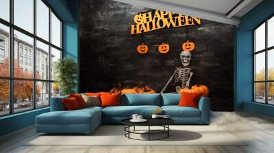 Halloween concept with a pumpkin and skeleton on background Wall mural