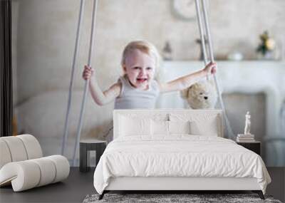 Child on a swing goes for a drive on a white background beautiful interior flowers Wall mural