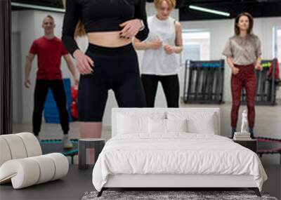 Women's and men's group on a sports trampoline, fitness training, healthy life - a concept trampoline batut instructor health, In the afternoon fit activity for training from young body, sportive Wall mural