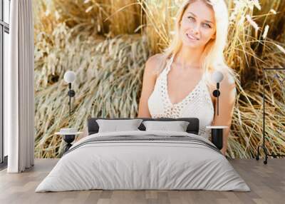 Attractive blonde walking and posing on a rye field in summer da Wall mural