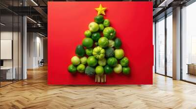 Christmas tree made from green vegetables and fruits on red background Wall mural