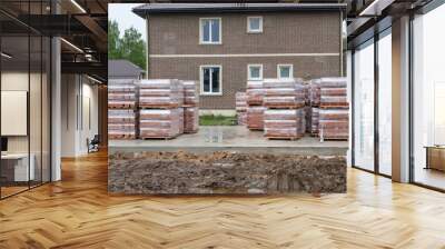 New brick pallets at new house construction site with house on the background Wall mural