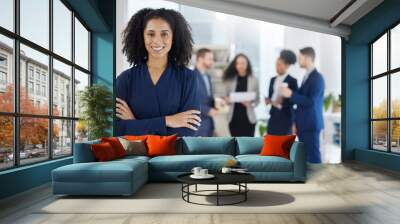 Crossed arms, leadership and portrait of businesswoman in the office with confidence, smile and team. Career, professional and young female corporate lawyer from Colombia in workplace with colleagues Wall mural