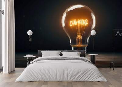 A burning light bulb in the dark. Wall mural