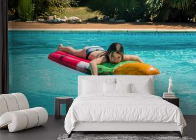 cute little girl lounging on her floating mattress Wall mural