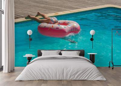 cute young girl playing in the pool with her inflatable donut Wall mural