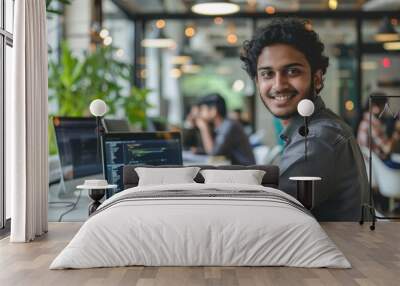 Portrait of young successful Indian man at workplace inside office, businessman smiling and looking at camera, man at work using laptop, programmer with curly hair coding, Generative AI Wall mural