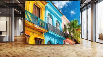 A colorful street scene with a palm tree in the background. The buildings are painted in different colors, creating a vibrant and lively atmosphere Wall mural