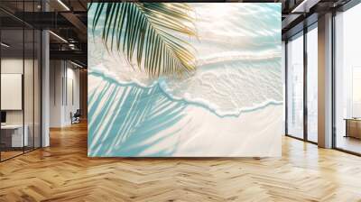 A palm tree is laying on the sand next to the ocean. The water is calm and the sun is shining brightly Wall mural