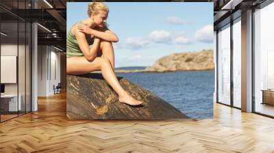 Young Woman doing Yoga on rocks Wall mural