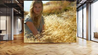 Young Woman Sitting in Long grass Wall mural