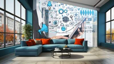 Businessman holding tablet device and touching screen by finger to discover future perspective in development of digital marketing. Social media icons sketched on foreground glass screen. Wall mural