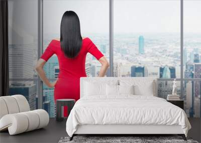 Rear view of gorgeous brunette in red dress posing on the modern panoramic office in New York City. Wall mural