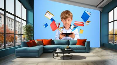 Serious boy with smartphone reading in digital library Wall mural